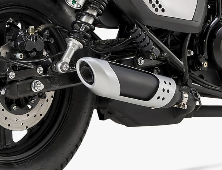 Knalpot bergaya cafe racer klasik terpasang di bagian bawah sasis dengan sudut sedikit menanjak dan pelindung panas berwarna perak.